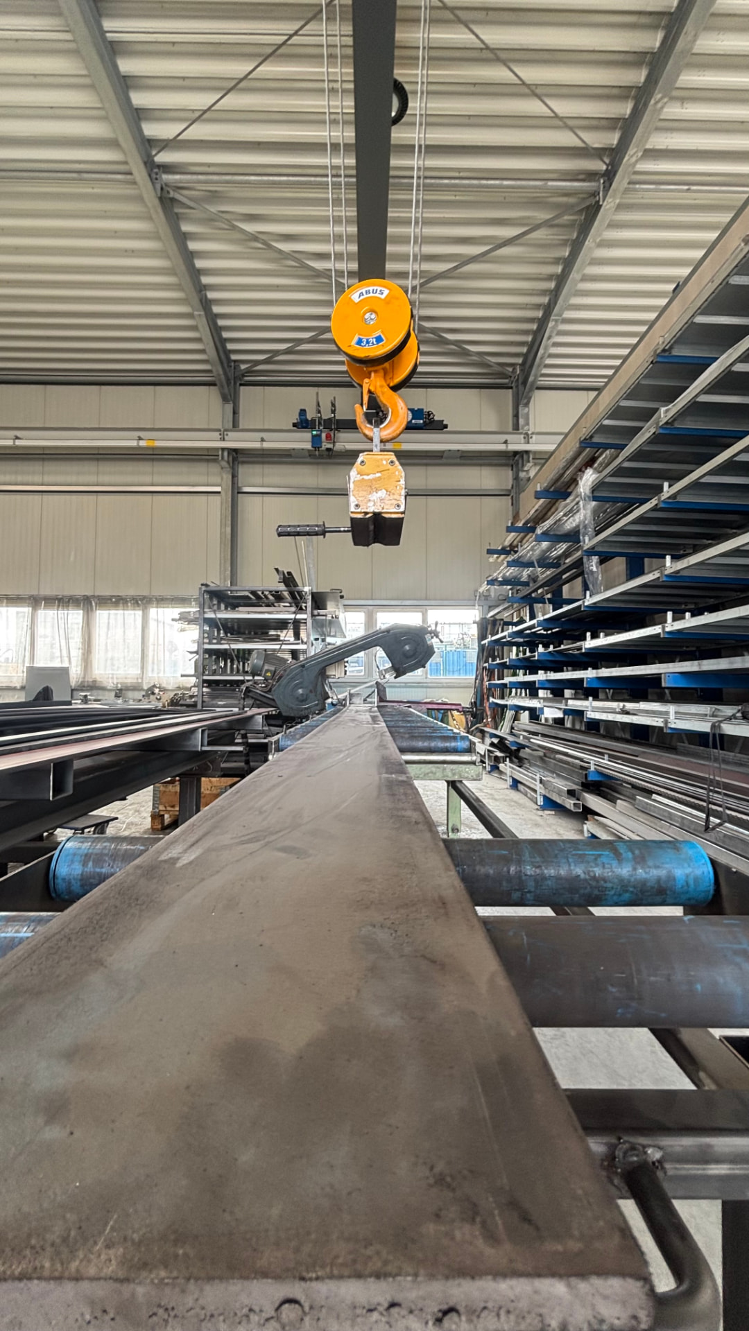 Hallenkran hebt ein Stahlbauteil in der Produktionshalle in Overath